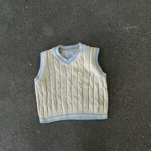 Cream colored sweater vest with baby blue around the edges
